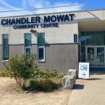 Entrance of Chandler Mowat Community Centre with a sign indicating EarlyON programs. The building has large windows and a sign above the entrance that reads 'CHANDLER MOWAT COMMUNITY CENTRE'. A white sign with 'EarlyON' and an arrow pointing right is placed near the entrance.